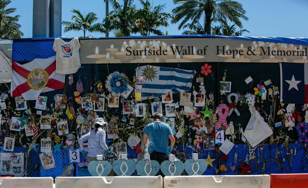 Workers for HistoryMiami bag items left on the Surfside memorial wall on Monday, August 30, 2021.