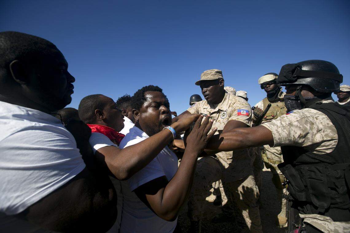 National police officers face anti-government protesters, who try to place flowers at Titanyen, a mass burial site, as Haiti’s President Jovenel Moise attends a memorial service honoring the victims of the 2010 earthquake in Port-au-Prince on Jan. 12, 2020. Sunday marked the 10th anniversary of the devastating 7.0 magnitude earthquake that destroyed an estimated 100,000 homes across the capital and southern Haiti, including some of the country’s most iconic structures.