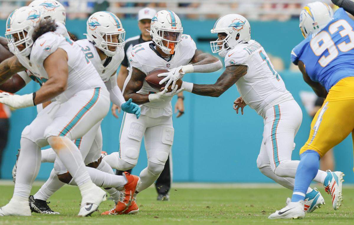 Miami Dolphins quarterback Tua Tagovailoa (1) passes the ball to Miami Dolphins running back Ollie Gordon II (31) in the first half during their NFL football game at Hard Rock Stadium in Miami Gardens, FL, on Sunday, October 12, 2025. 