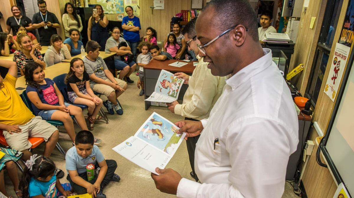 Andail Chung, left, and Sergio Benitez of Fresco y Más grocery store read to local students after donating 6,000 books, in English and Spanish, to several Miami-Dade migrant labor camps on behalf of Winn-Dixie, Fresco y Más and Kellogg’s associates.