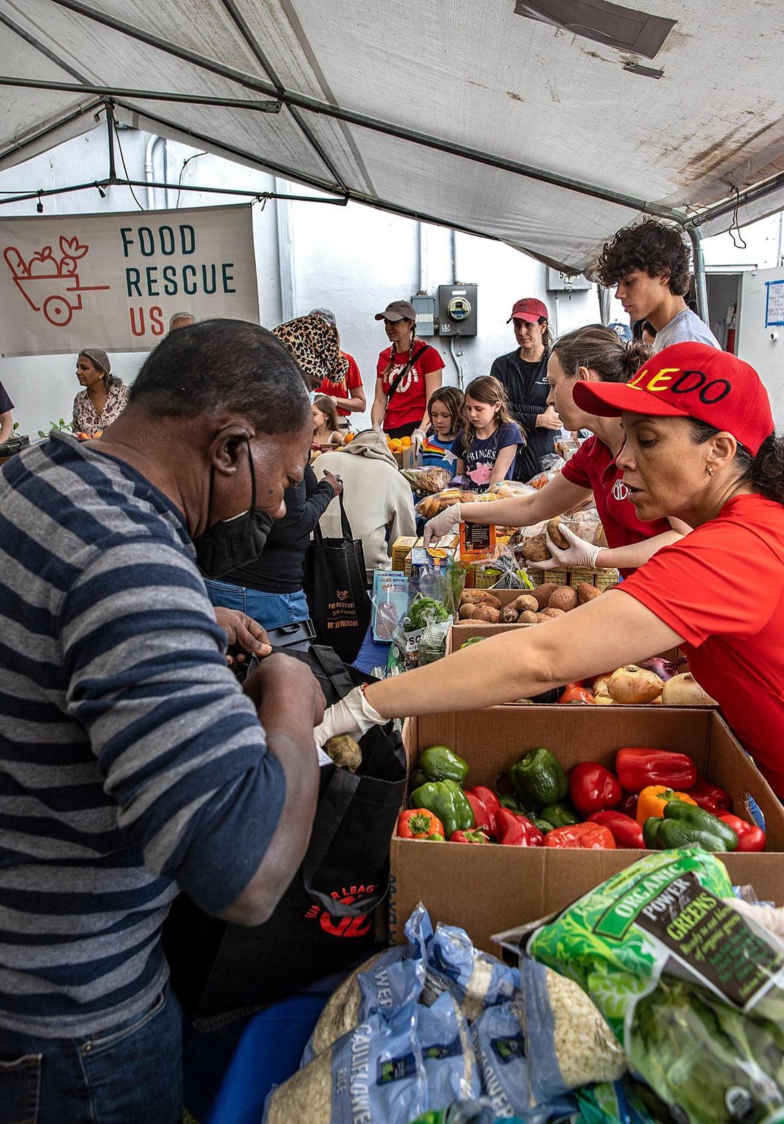 Volunteers distribute goods including vegetables, meat, pastries, bread, rice, dairies, flowers, etc, to people in need during a monthly event organized by the South Florida chapter of Food Rescue US in Liberty City. Local volunteer groups pick up food/ingredients that would have been thrown out from restaurants, hotels, events, etc. and distribute it for free to people in food deserts. on Saturday January 28, 2023.