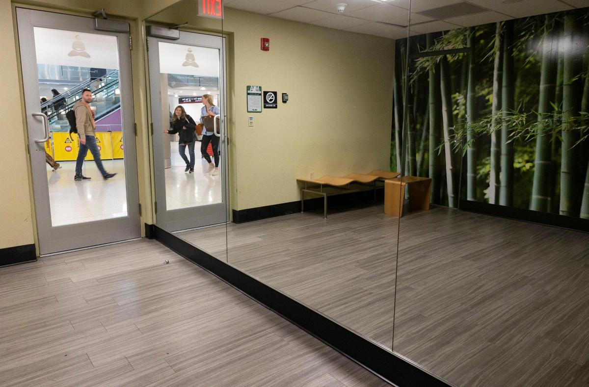 People walk passed the Yoga Room on their way to and from their flights during the day on Monday, Jan. 29, 2024, at Miami International Airport.