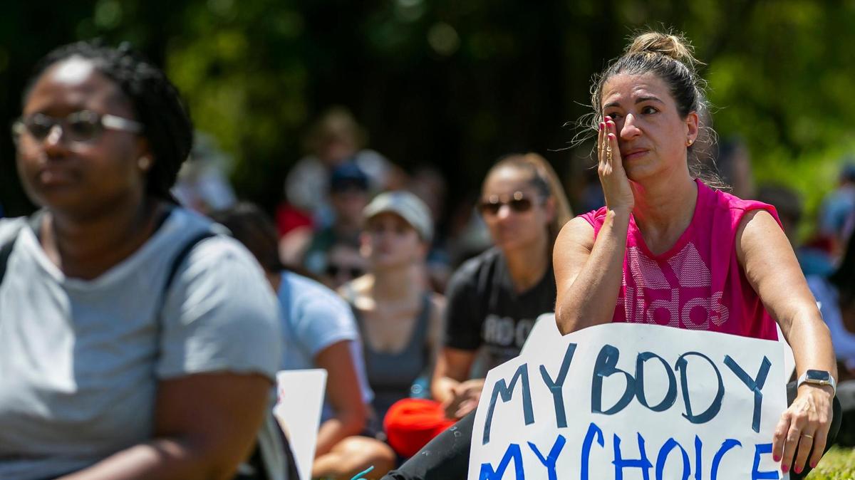 Maria Laura Alfonsin wipes a tear as she listens to speakers at the “Bans Off Our Bodies” rally at Ives Estates Park in Miami, Florida on Saturday, May 14, 2022. The rally was held in opposition of the leaked draft opinion from SCOTUS which aims to overturn Roe v. Wade, removing women’s constitutional right to an abortion.