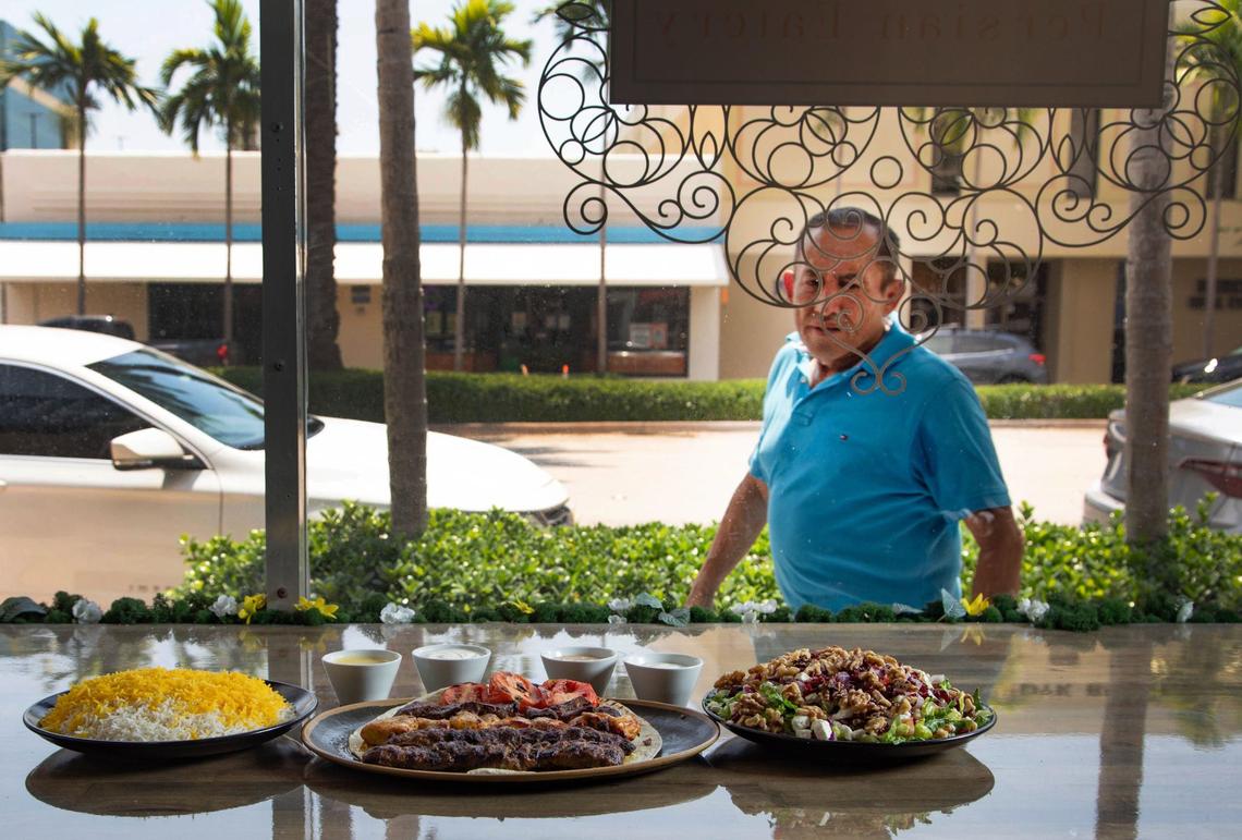 A passerby checks out the the marinated beef, lamb and chicken kabobs with rice and salad at Shahs of Kabob in Coral Gables.