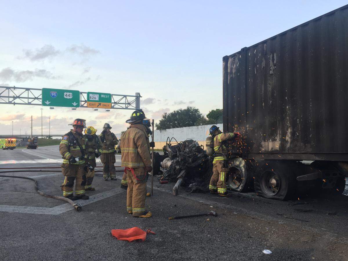 Miami-Dade Fire Rescue workers cut a hole in the cargo part of the truck to get to the fire inside Thursday morning.
