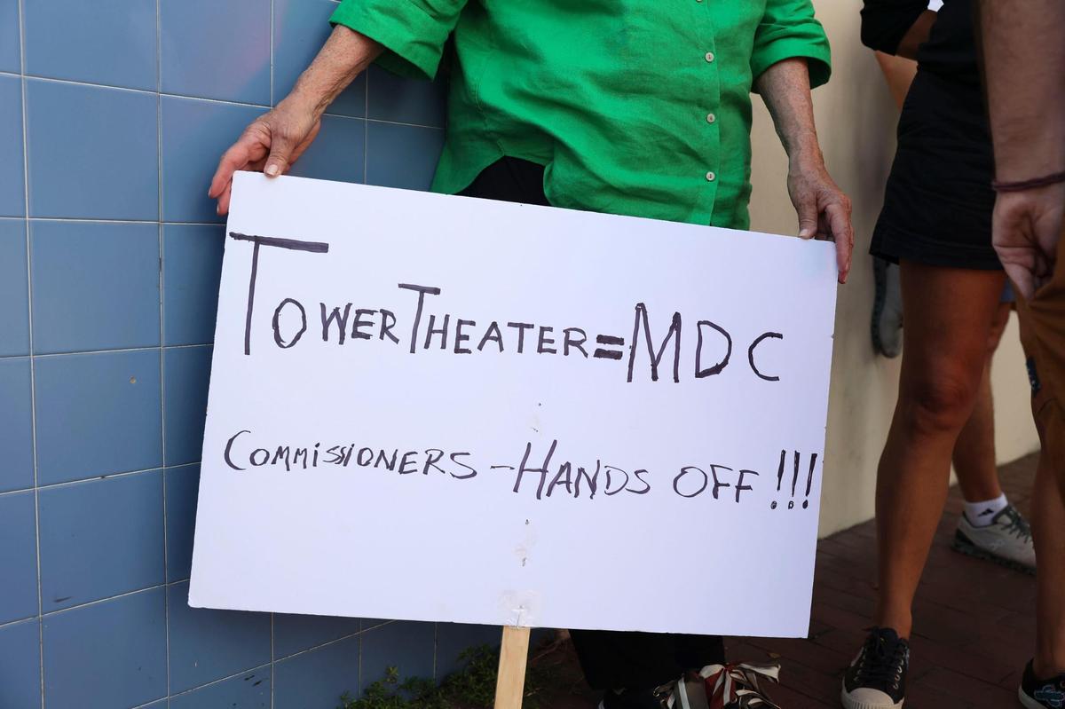 Margarita Battle, fiel asistente al teatro, sostiene su cartel durante la protesta en el Tower Theater por la salida del Miami-Dade College como su operador, el martes 4 de octubre de 2022, en La Pequeña Habana.