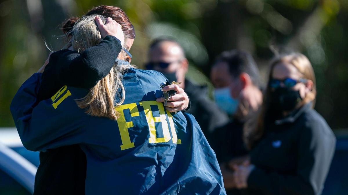 An FBI agent is consoled near the Broward County Office of Medical Examiner and Trauma Services in Fort Lauderdale on Feb. 2, 2021. Two FBI agents were shot and killed and others injured while serving a warrant at a Sunrise home.