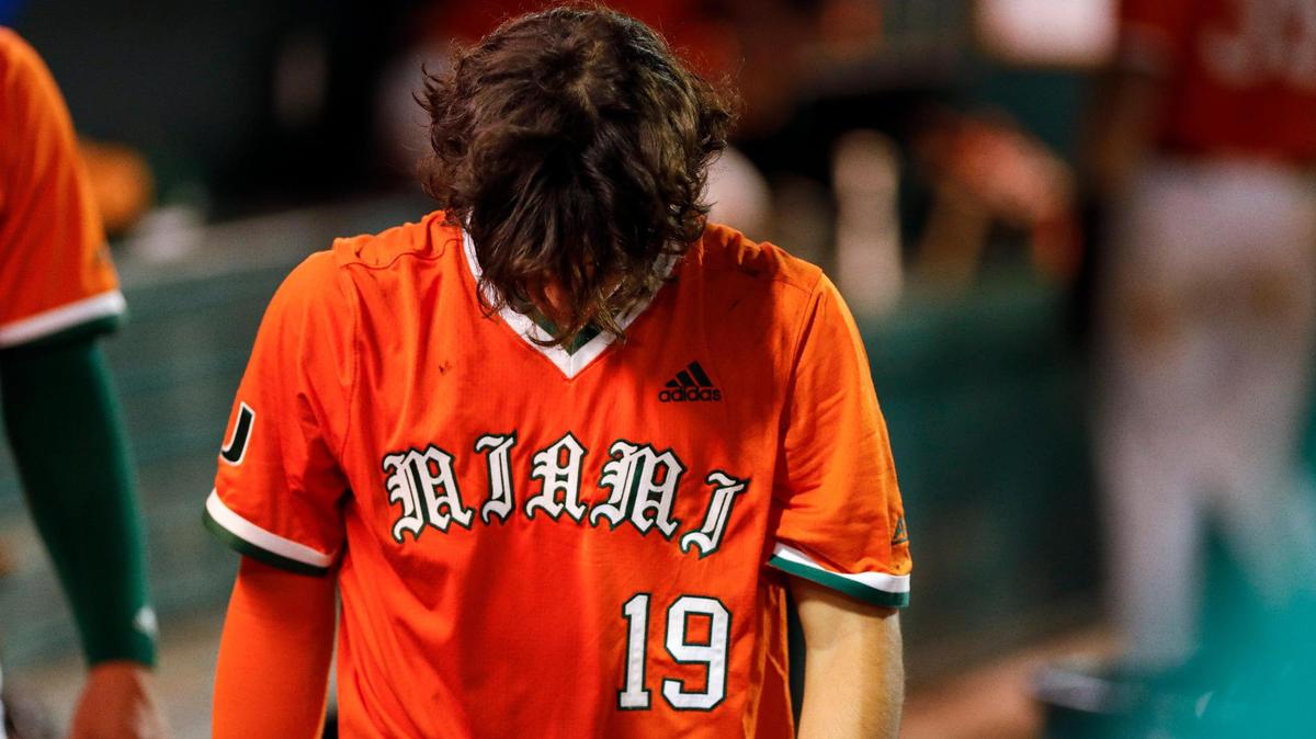 Miami Hurricanes infielder Dominic Pitelli (19) walks with his head down inside the dugout after loosing the game against the Arizona Wildcats during the Coral Gables NCAA Baseball Regional at Alex Rodriguez Park at Mark Light Field in Coral Gables, Florida, Sunday, June 5, 2022.