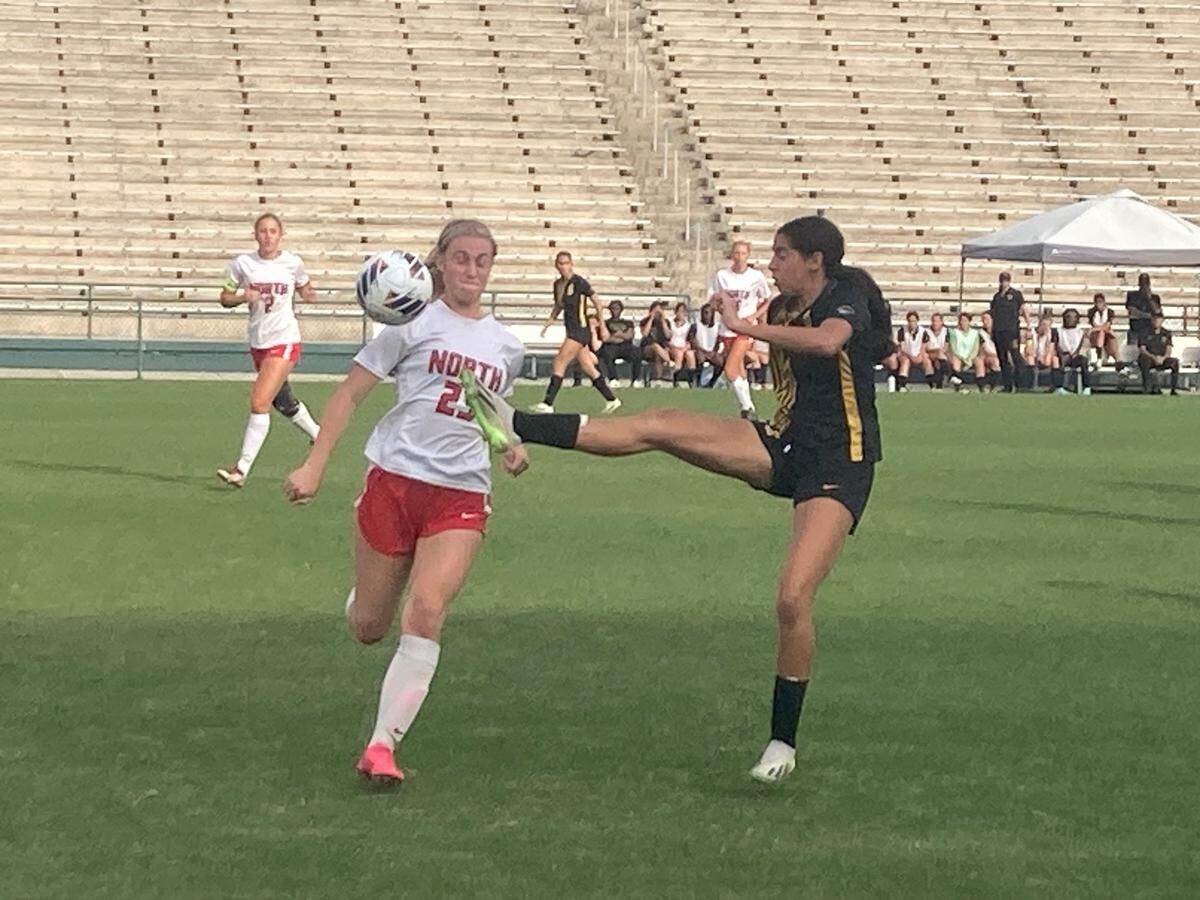 American Heritage’s Emma Torres attempts to kick the ball just as north Fort Myers’ Hannah Busenbark challenges during Friday’s Class 5A state championship match at Spec Martin Stadium in DeLand, Fla.