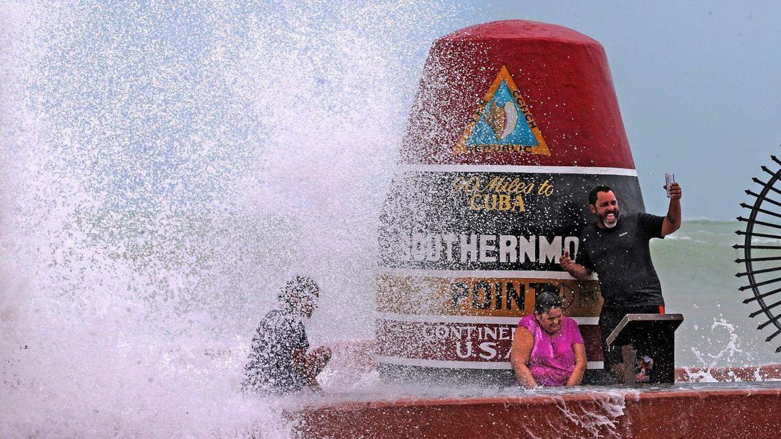 Key West resident Pedro Lara takes a selfie in front of the Southernmost Point marker as waves from Hurricane Irma crash over the wall, September 9, 2017.