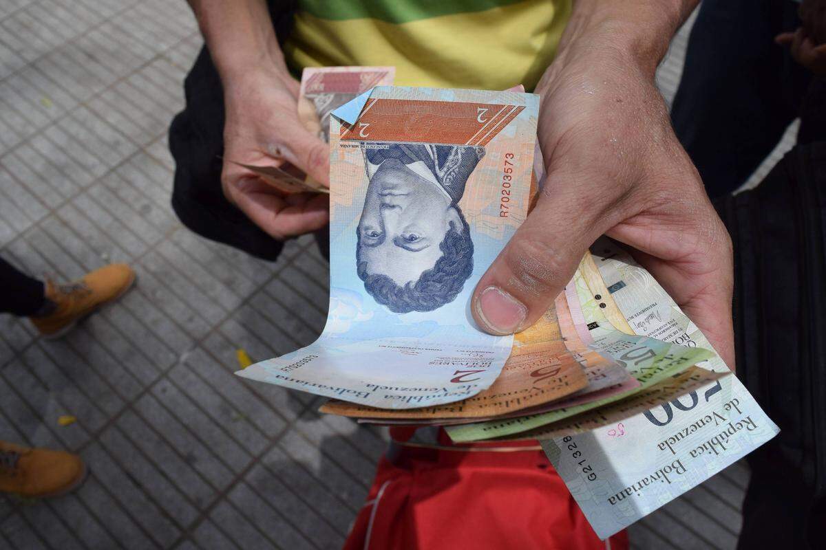 A man gives away Venezuelan bank notes in Cúcuta, Colombia. Venezuela's bolivar has lost most of its value due to the country's hyperinflation.