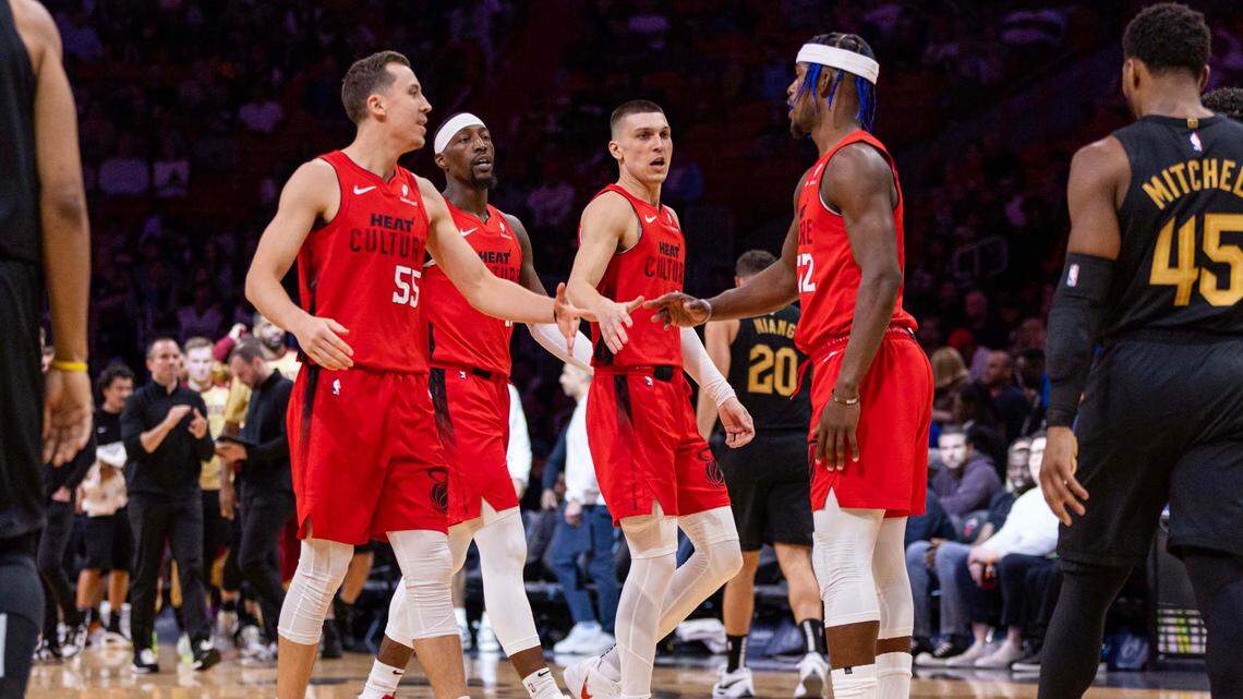Miami Heat forward Jimmy Butler (22) reacts with teammates Duncan Robinson (55), Bam Adebayo (13) and Tyler Herro (14) during the second half of an NBA game at Kaseya Center on Dec. 8, 2024, in Miami.