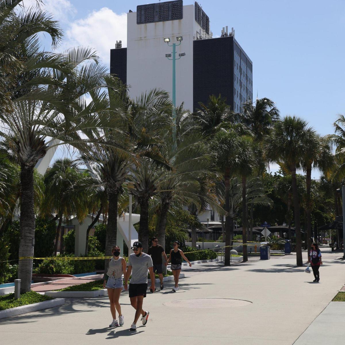 Visitors to Lincoln Road walk past the broken clock atop the building at 407 Lincoln Road on Wednesday, May 26, 2021.