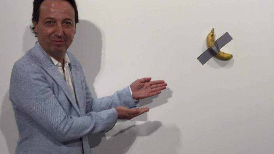 Gallerist Emmanuel Perrotin shows off ‘Comedian,’ a work by Italian bad-boy artist Maurizio Cattelan that consists of a banana taped to the wall. The piece, one of three bananas on exhibit at the Art Basel Miami Beach fair, sold for $120,000, Perrotin said.