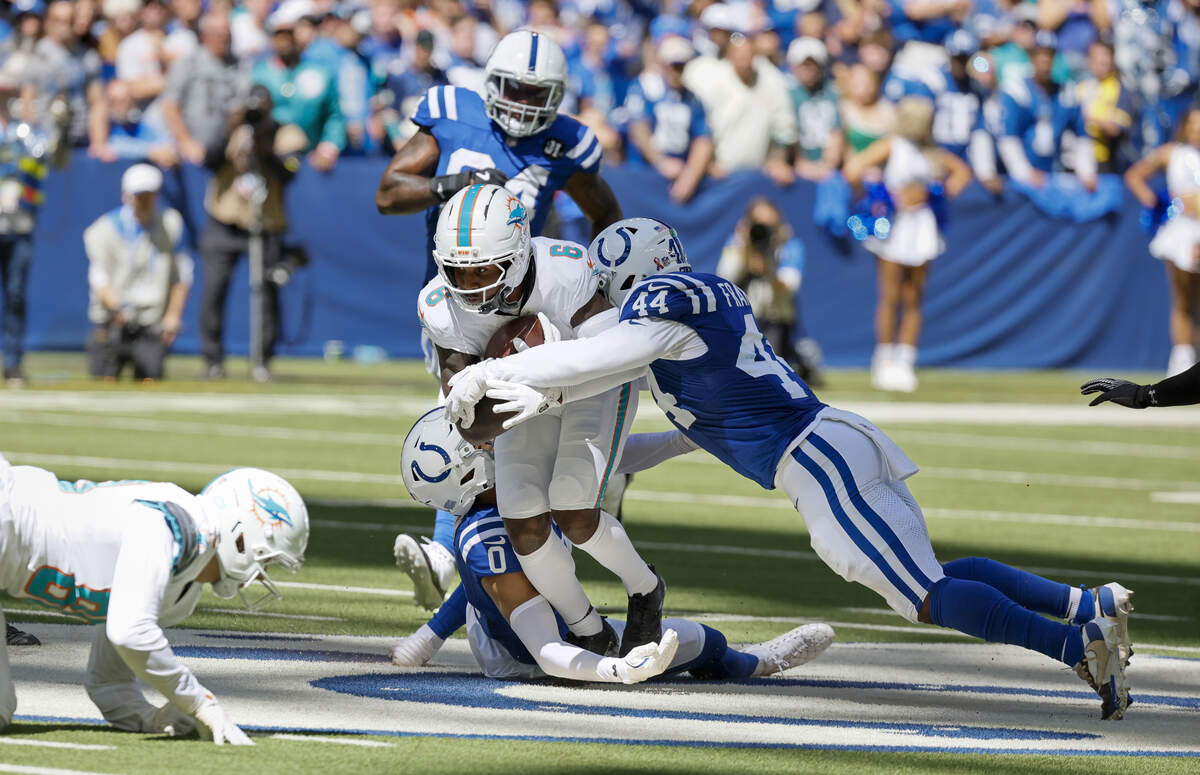 Miami Dolphins wide receiver Malik Washington (6) is brought down by Indianapolis Colts safety Cam Bynum (0) and linebacker Zaire Franklin (44) during the first half of an NFL game at Lucas Oil Stadium on Sunday, Sept. 7, 2025, in Indianapolis.