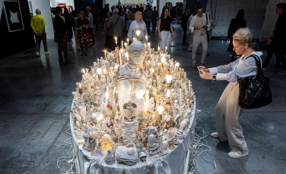 Elena Kazlas, from Boston, takes a photo of ‘Bound Angel’ by Portia Munson during Art Basel at the Miami Beach Convention Center on Wednesday, Dec. 4, 2024, in Miami Beach, Fla.
