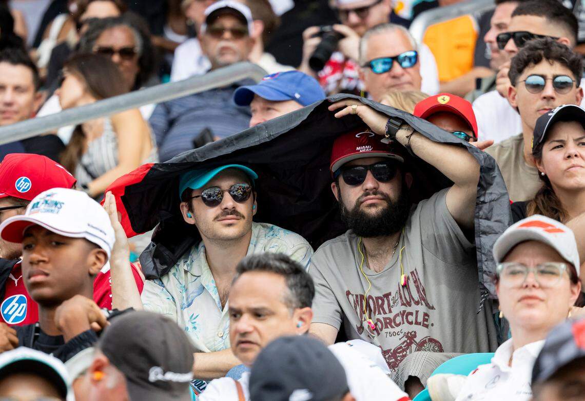Fans cover from the rain as they watch drivers participate in the Formula One Miami Grand Prix at the Miami International Autodrome on Sunday, May 4, 2025, in Miami Gardens, Fla.