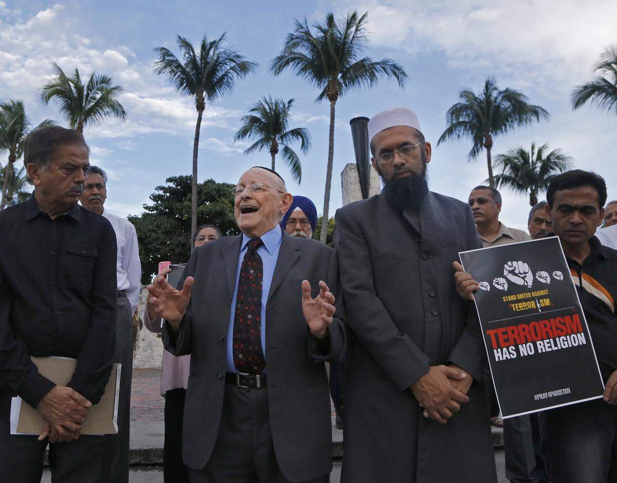 In the center, Rabbi Solomon Schiff joins in solidarity with members of the Muslim faith denouncing the killing of children by extremists. Members of the tri-county Pakistani community gathered at the Torch of Friendship to host a vigil in honor the 141 children and adults that were killed by extremists in Peshawar, Pakistan, on Sunday, December 21, 2014.