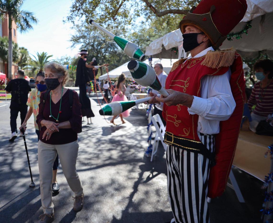 Juggler Kenny Cowden, right, juggles pins as residents enjoy the holiday festive party. Performers - jugglers, stilt walkers, and others in holiday festive costumes entertained residents of the Palace Suites as senior and love ones gathered while socially distancing during its Family Holiday Jam on Sunday, December 13, 2020.