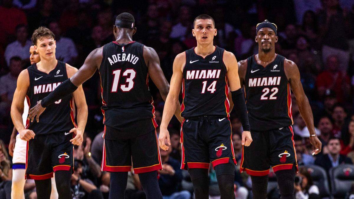Miami Heat players Tyler Herro (14), Bam Adebayo (13), Pelle Larsson (5) and Jimmy Butler (22) react to a play during the second half of an NBA game against the Sacramento Kings at the Kaseya Center on Monday, November 4, 2024, in Miami, Fla.