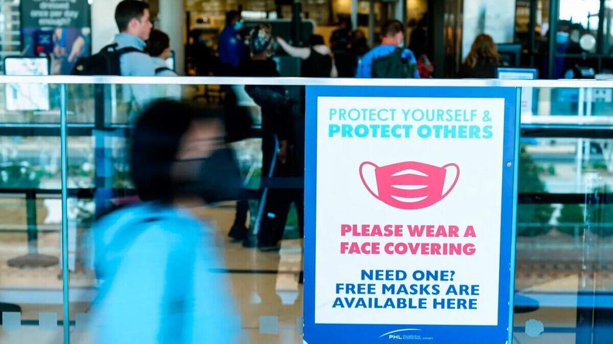 A sign at Philadelphia International Airport urges travelers to wear a protective masks as a precaution against the coronavirus.