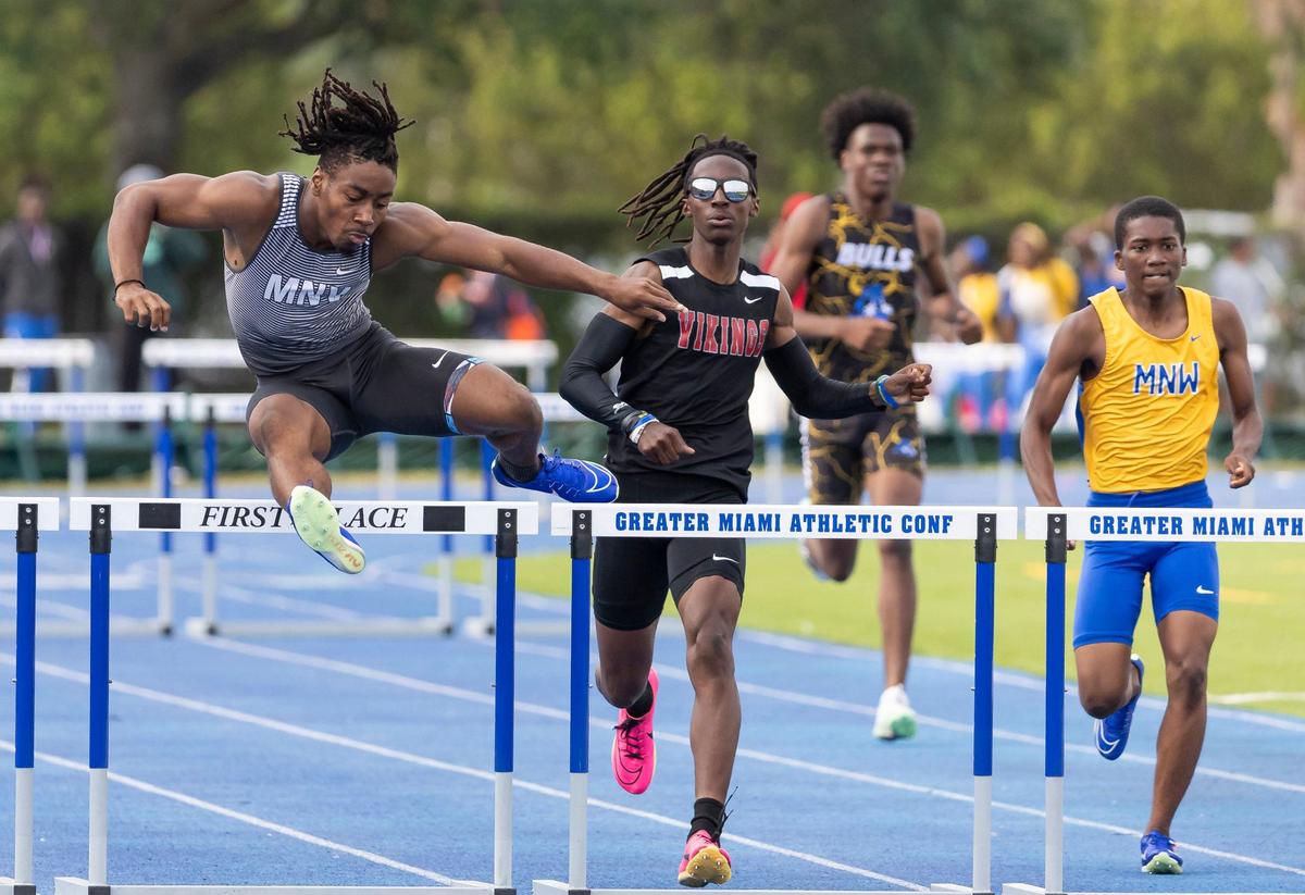 Isaiah Scott, left, from Miami Norland Senior High School, competes in the boys 400 meter hurdles during the GMAC track and field championships at the Traz Powell Stadium on Thursday, April 11, 2024, in Miami, Fla.