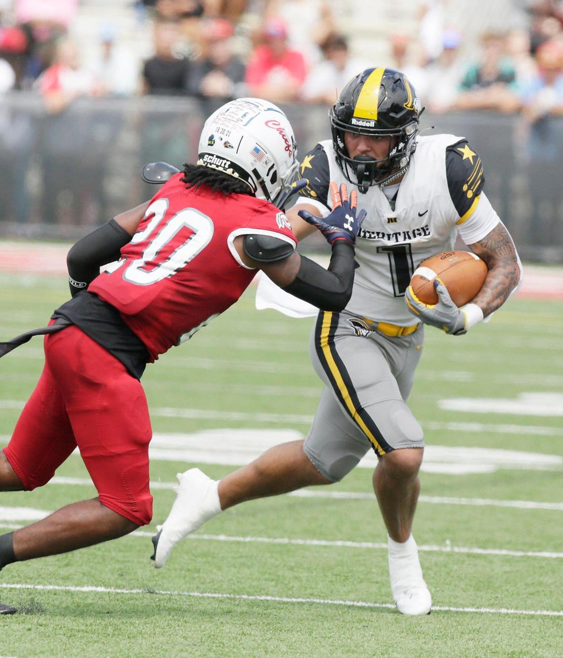 American Heritage Patriots wide receiver Brandon Inniss (1) tries to escape with the ball during football game against Cardinal Gibbons Chiefs on Saturday, October 1, 2022 at Cardinal Gibbons HS in Fort Lauderdale. Andrew Uloza / for Miami Herald