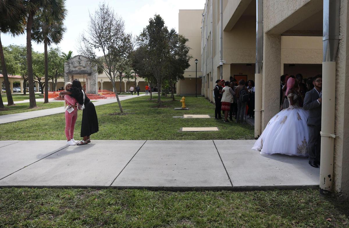 Rakaya Johnson, senior, center, hugs her friend Onaejah Alexander, left, before the Student Awards Ceremony Tuesday, May 24, 2022, in Miami at Booker T. Washington Senior High School in Overtown.