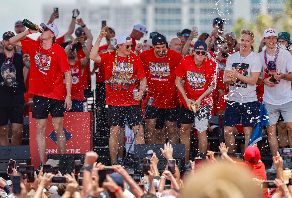 Florida Panthers defenseman Niko Mikkola, center Anton Lundell, defenseman Jaycob Megna, center Jesper Boqvist, defenseman Gustav Forsling, and center Eetu Luostarinen spray champagne toward fans while celebrating on stage during the Panthers’ Stanley Cup victory parade and rally along A1A in Fort Lauderdale, Florida, on Sunday, June 22, 2025.