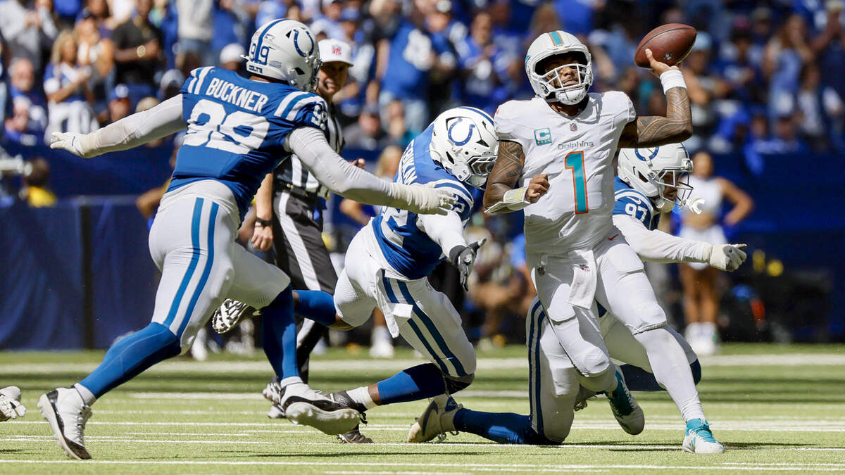 Miami Dolphins quarterback Tua Tagovailoa (1) under pressure by Indianapolis Colts defensive end Laiatu Latu (97), defensive end Samson Ebukam (52) and defensive tackle DeForest Buckner (99) during the second half of an NFL game at Lucas Oil Stadium in Indianapolis on Sunday, September 7, 2025, in Indianapolis.