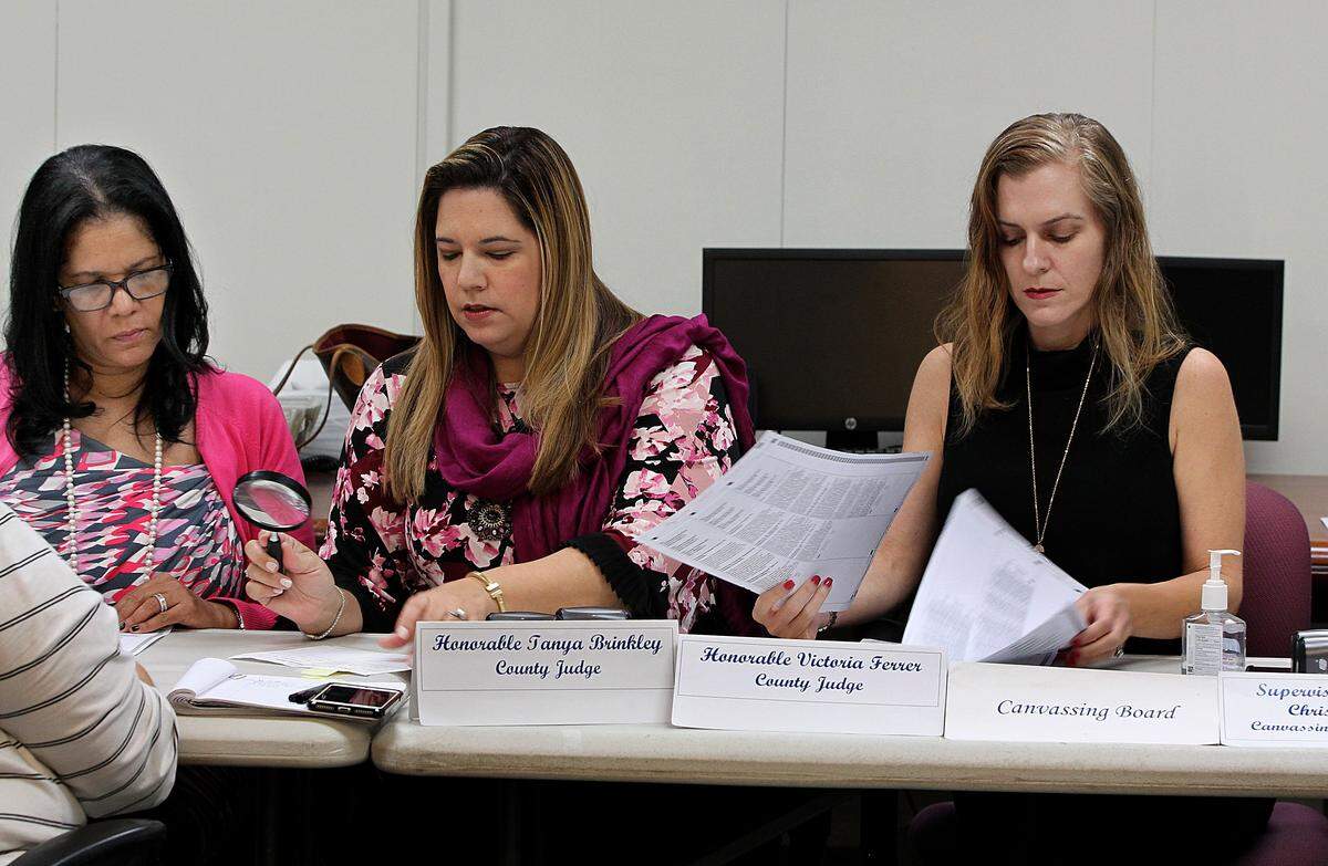 Miami-Dade County Elections Department members, from left, County Judges Tanya Brinkley and Victoria Ferrer with Christina White, Miami-Dade County Elections Supervisor, review ballots as part of the recount process in Doral on November 17, 2018.