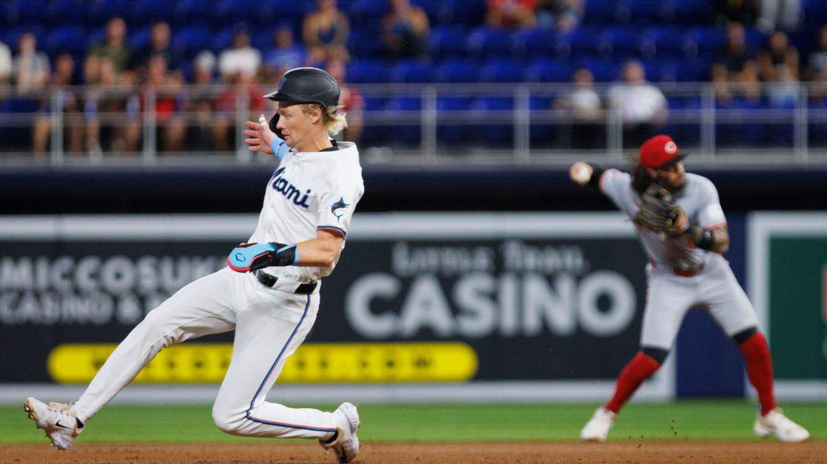 Miami Marlins outfielder Kyle Stowers (28) runs to second base as Cincinnati Reds second baseman Jonathan India (6) throws to first for an out during the second inning of a baseball game on Thursday, Aug. 8, 2024, at loanDepot Park in Miami.