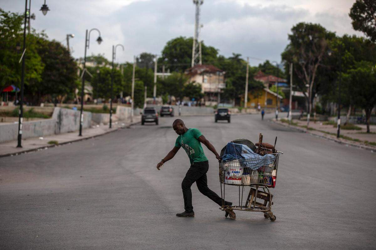 A man pulls a loaded shopping cart through a street, empty due to the general strike in Port-au-Prince, Haiti, Monday, Oct. 18, 2021.