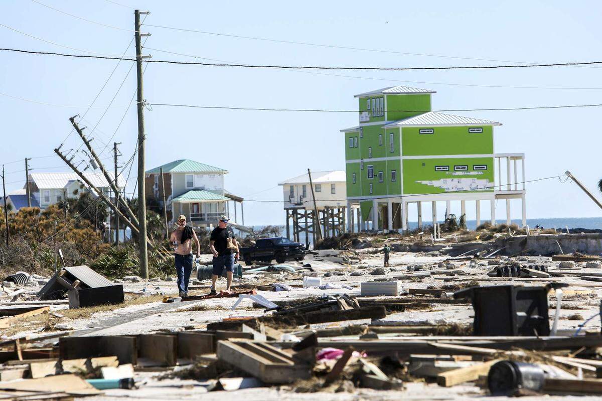 Randy Fike, left, and his brother Troy walk Saturday toward his home for the first time after Hurricane Michael made landfall near Cape San Blas on Wednesday. Randy Fike was going to look for the ashes of his late wife, Judy Caldwell.