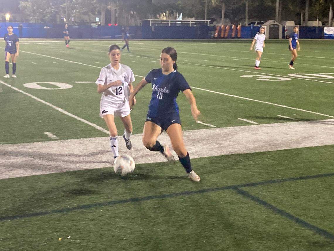 University School’s Mia Herrera (right) battles Gulliver Prep’s Elisa Senior for possession of the ball during Friday night’s girls Region 4-3A semifinal at Auto Nation Field in Davie.