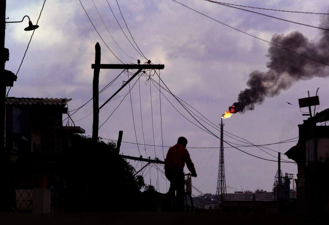 A Cuban rides a bicycle in Havana near the Nico Lopez oil refinery in this file photo. Exxon claims the refinery was confiscated by the Fidel Castro government without compensation in 1960 and is suing in federal court.