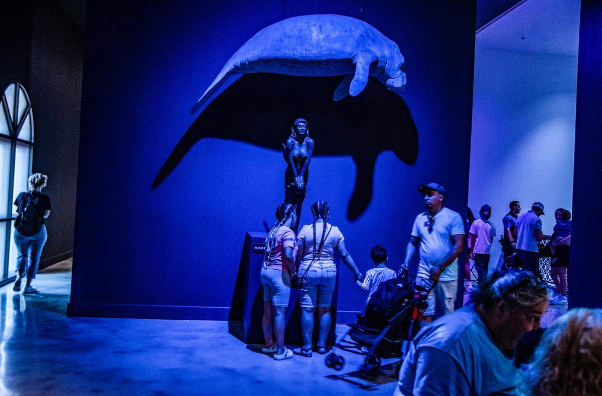 Visitors look at a Manatee and a Mermaid, part of the “Mythic Creatures: Dragons, Unicorns & Mermaids”, exhibition on display at the HistoryMiami Museum, The exhibition opening on July 8th, traces the natural and cultural roots of some of the world’s most enduring mythological creatures from Asia, Europe, the Americas, and beyond, and even how Miamians embrace their own mythic fantasies. Organized by theAmerican Museum of Natural History in New York, on Saturday, July 08, 2023.