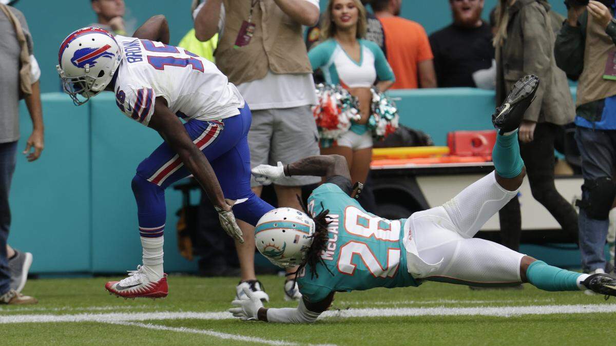 Buffalo Bills wide receiver John Brown (15) escapes a take by Miami Dolphins strong safety Bobby McCain (28) to score a touchdown, during the first half at an NFL football game, Sunday, Nov. 17, 2019, in Miami Gardens, Fla. (AP Photo/Lynne Sladky)