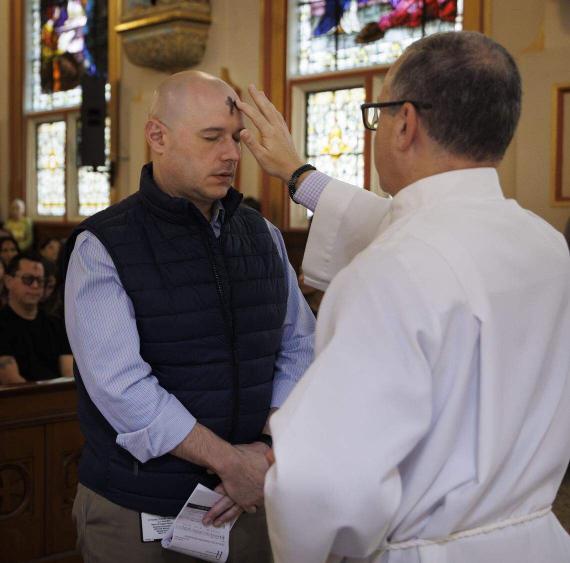A parishioner receives ashes from a Deacon during Ash Wednesday mass on Wednesday, Feb. 18, 2026, at Gesu Catholic Church in downtown Miami. The mass was fully packed with standing rom only at the back of the church. 