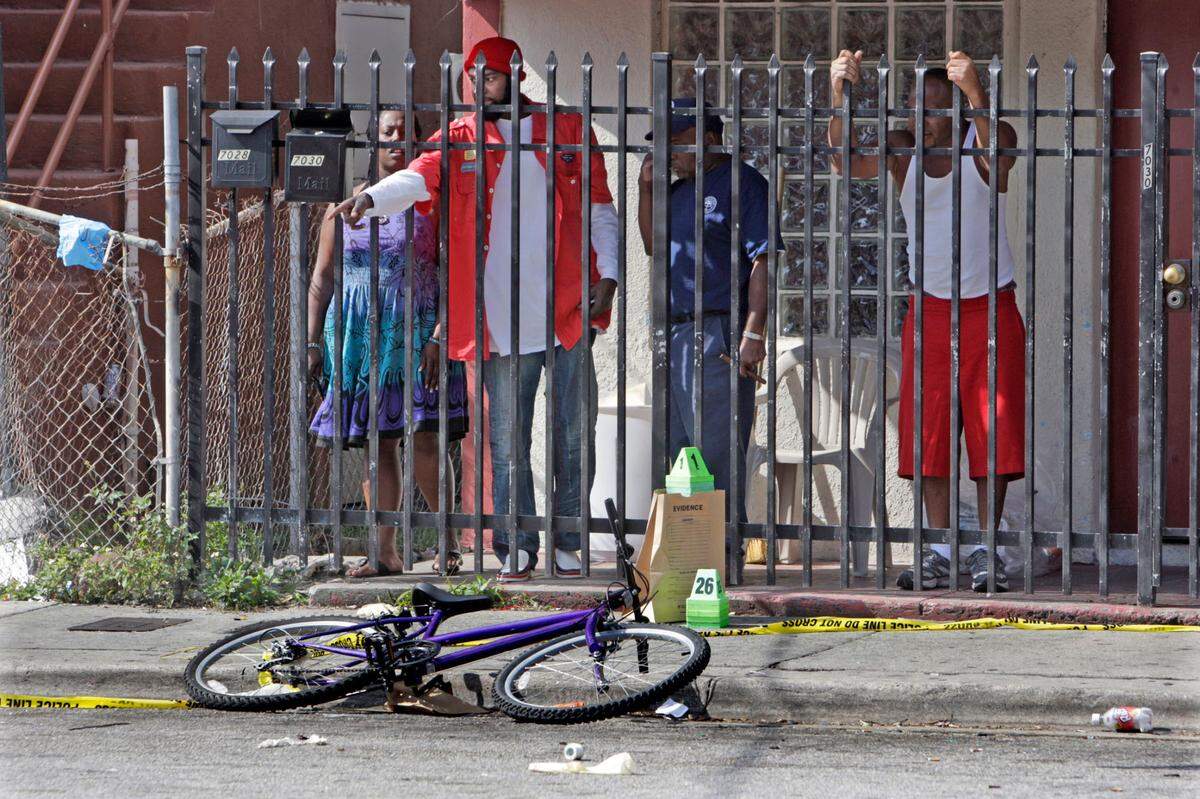 This photo from after the 2009 shooting shows Dorie Brewton pointing to the crime scene as he and friends discuss the violence in the neighborhood.