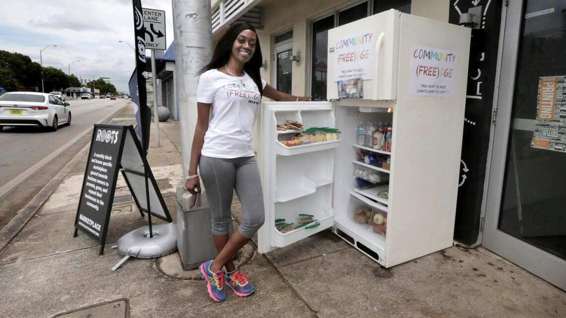 Sherina Jones and a fully stocked refrigerator in front of the Roots Collective in Miami, Florida. Jones set up this community fridge to help the food insecure during the COVID-19 crisis.