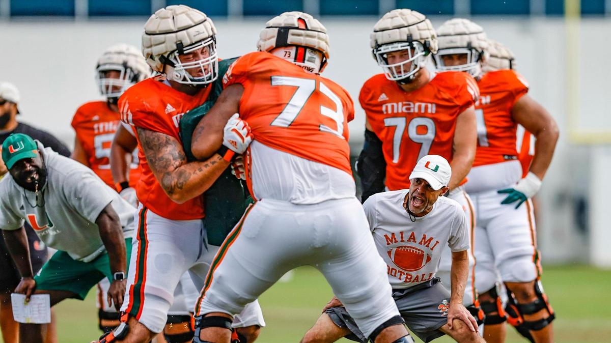 Miami Hurricanes offensive line coach Alex Mirabal and assistant offensive line coach Edwin Pata direct the players during practice drills at Greentree Field on the University of Miami campus in Coral Gables on Thursday, March 30, 2023.