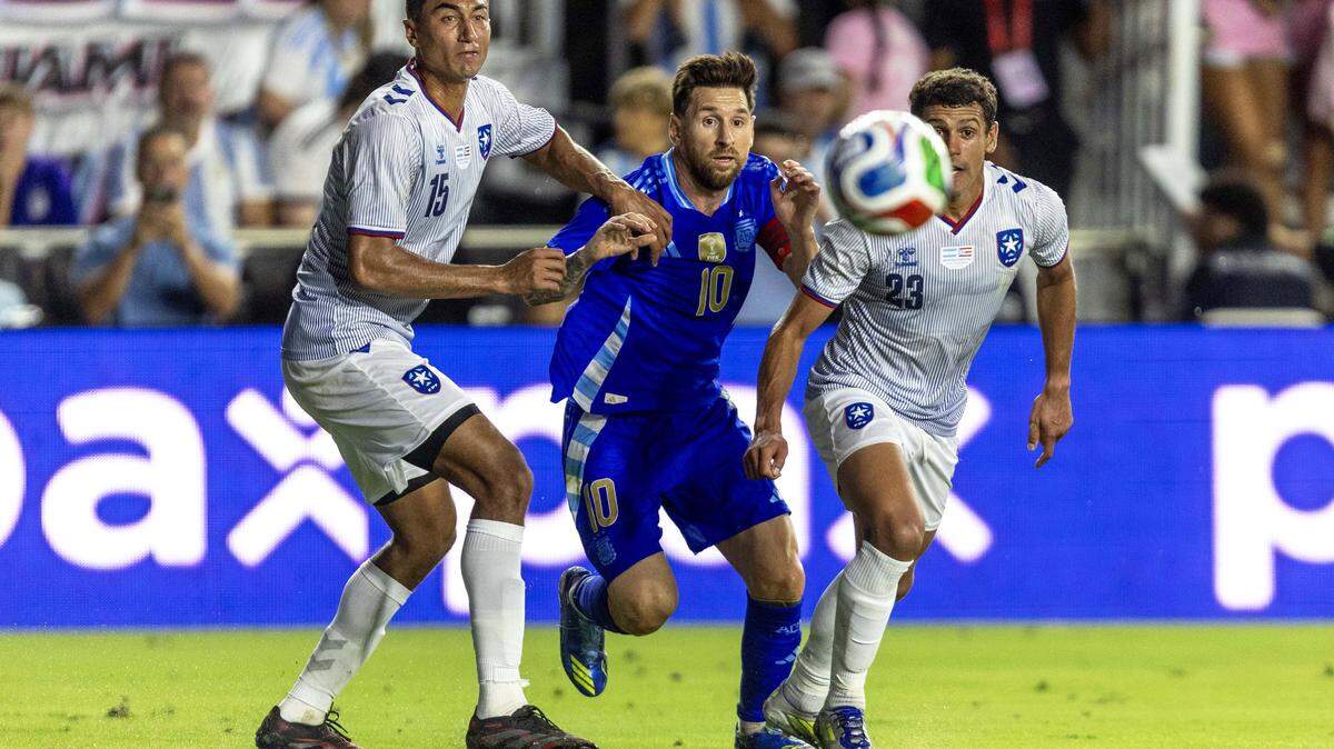 Argentina forward Lionel Messi (10) passes the ball while defended by Puerto Rico left back Gio Calderón (15) and midfielder Steven Echevarria (23) during the first half of an international team friendly at Chase Stadium on Tuesday, October 14, 2025, in Fort Lauderdale, Fla.