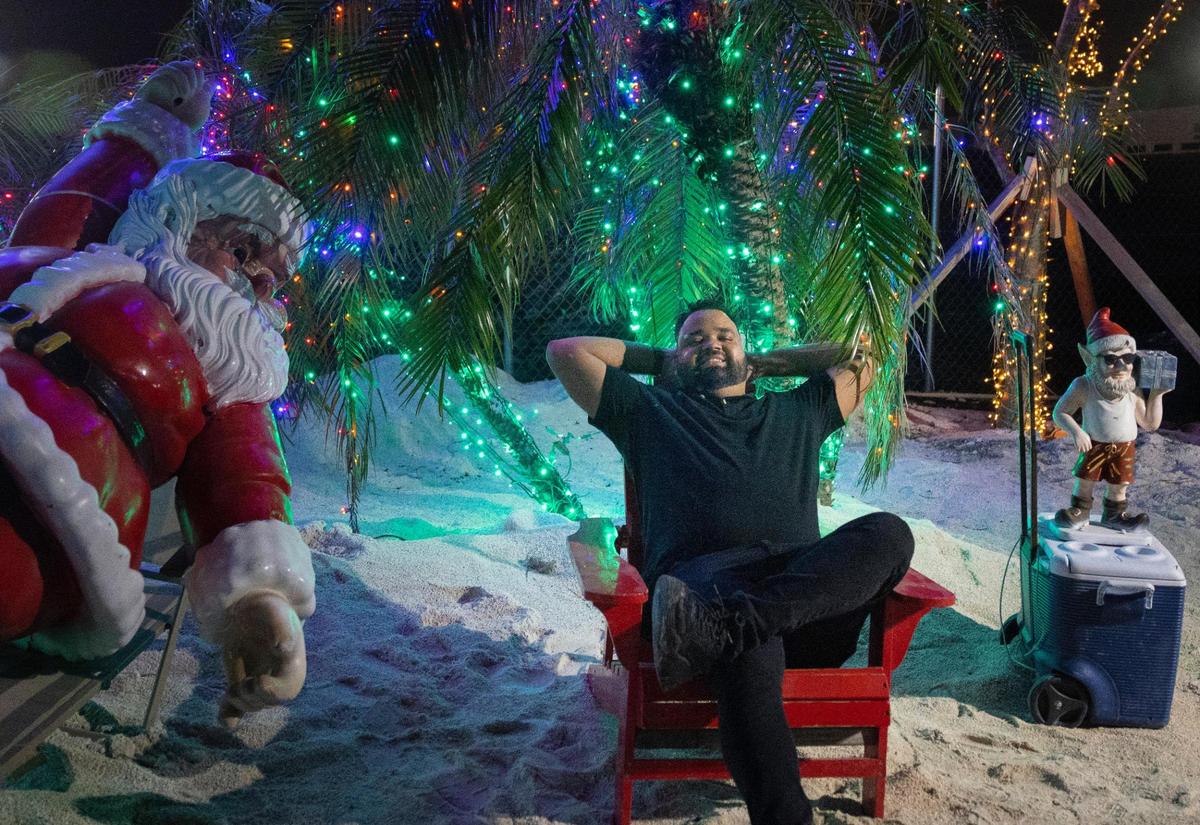 Juan Batista lounges next to a Santa during the opening night of Santa’s Enchanted Forest.