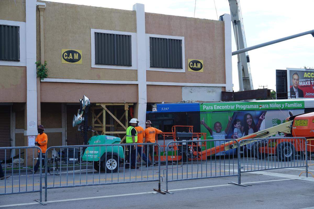 On Sept. 20, 2018, Ebsary Foundation workers try to remove the Miami-Dade County bus that crashed into the 92-year-old building at Northwest 54th Street and Second Avenue on Sunday, Sept. 16, 2018. The driver of a pickup truck ran a red light and hit the bus, causing it to careen into the building, which houses Omega Fashions.