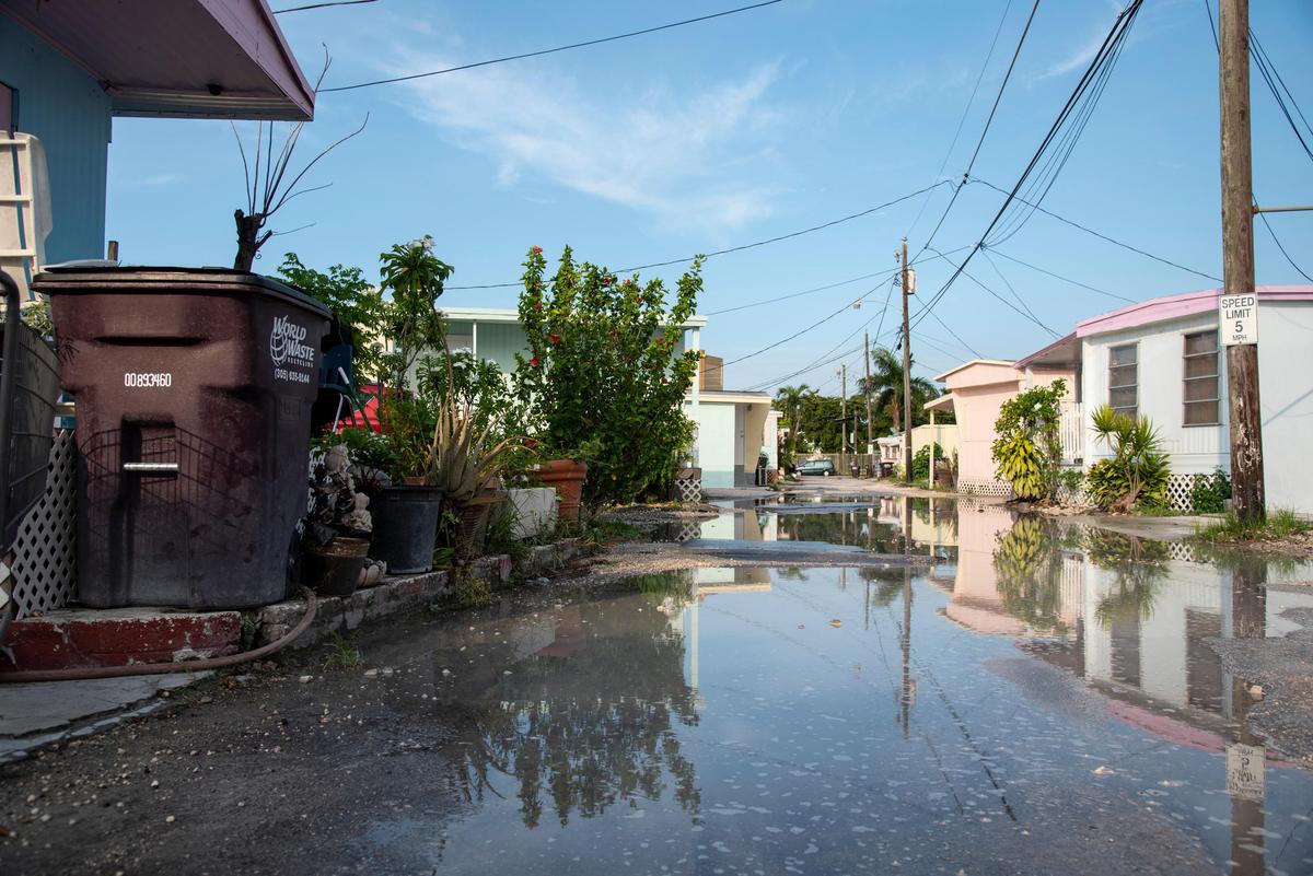 Streets are flooded with leftover rainwater from a storm in the streets of Miami Soar mobile home park on June 24, 2019.