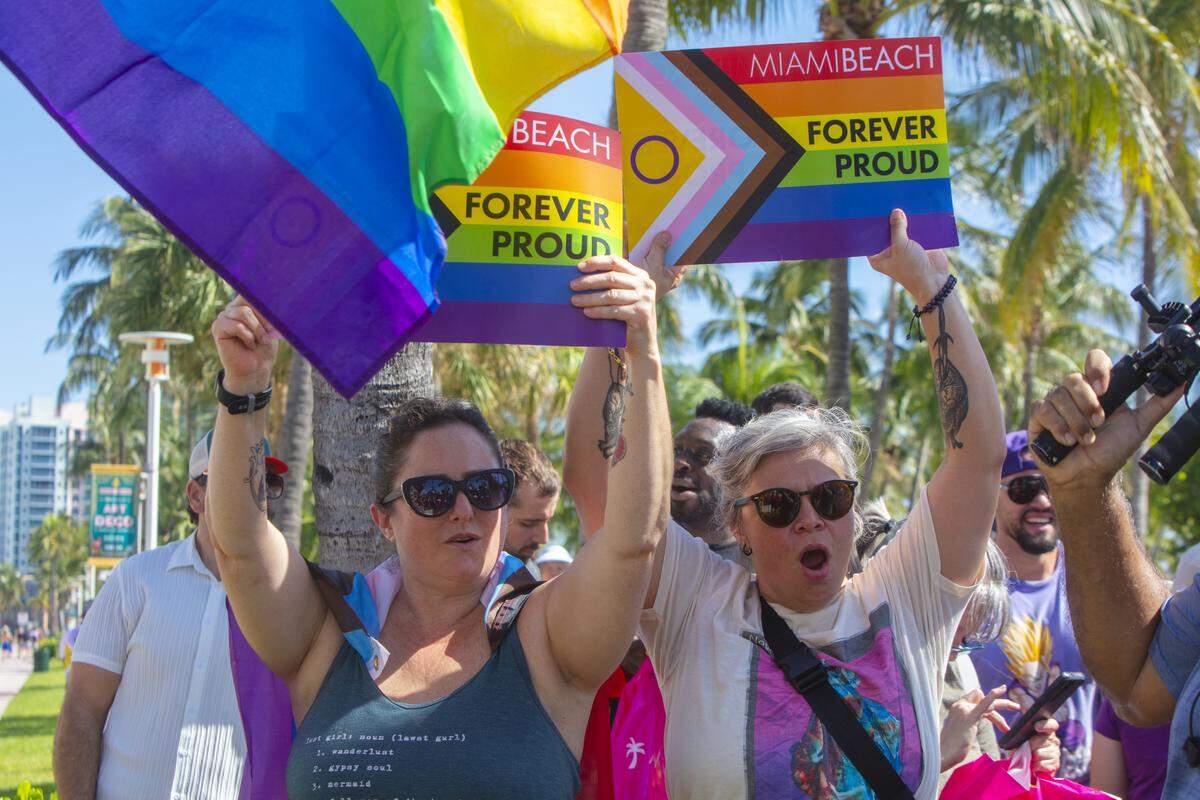 From left, Adriana May and Cynthia Ordaz rally with other demonstrators carrying rainbow flags and signs reading ‘Miami Beach Forever Proud’ and ‘Won’t Be Erased’ during the Forever Proud March on Ocean Drive in Miami Beach, Fla., Sunday, Aug. 31, 2025. The march followed state officials’ order to remove the city’s LGBTQ Pride crosswalk.