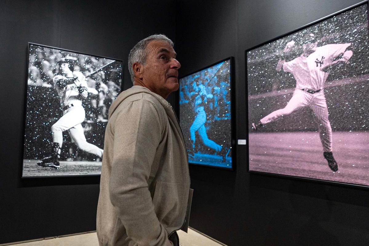 Miami resident Steve Miller looks around the gallery space at ‘The Swing’ and ‘The Jump’, both pieces by artist Russell Young, on display during Art Miami at One Herald Plaza on Tuesday, Dec. 3, 2024, in Miami, Fla. Young was commissioned by the MLB to create an artwork featuring Derek Jeter.