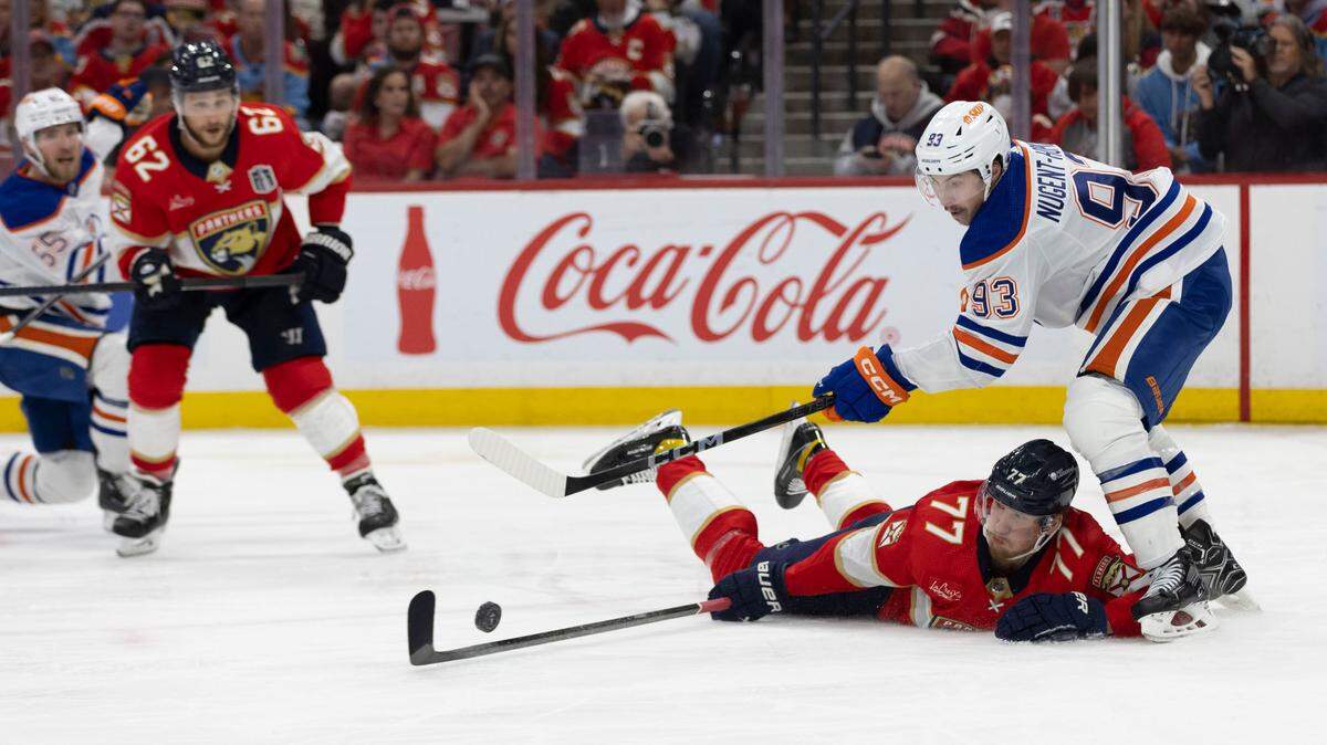 Sunrise, Florida, June 18, 2024 - Florida Panthers defenseman Niko Mikkola (77) fights for the puck with Edmonton Oilers center Ryan Nugent-Hopkins (93) in second period action of Game 5.