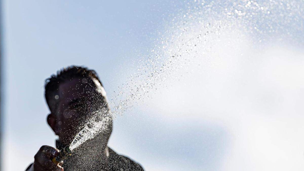 Andres Martinez cleans the Schwartz Center for Athletic Excellence at the University of Miami on Tuesday, Aug. 8, 2023, in Coral Gables, Fla. You may want to feel a spritz from a hose like this on Memorial Day weekend in South Florida on May 24-27, 2024, as the National Weather Service forecasts near record temperatures in the 90s, with heat index readings around 100 to 105.